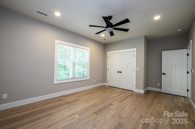 unfurnished bedroom with ceiling fan, light hardwood / wood-style floors, and a closet