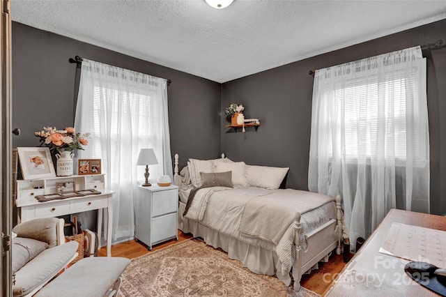 bedroom featuring light hardwood / wood-style floors and a textured ceiling