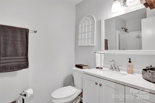 bathroom with vanity, toilet, and a shower with shower door