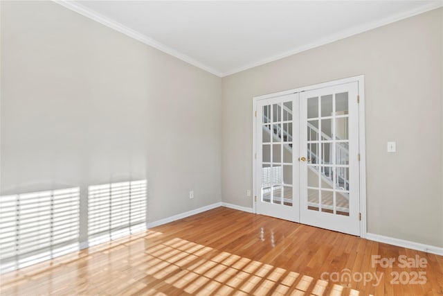 empty room featuring french doors, hardwood / wood-style floors, and ornamental molding