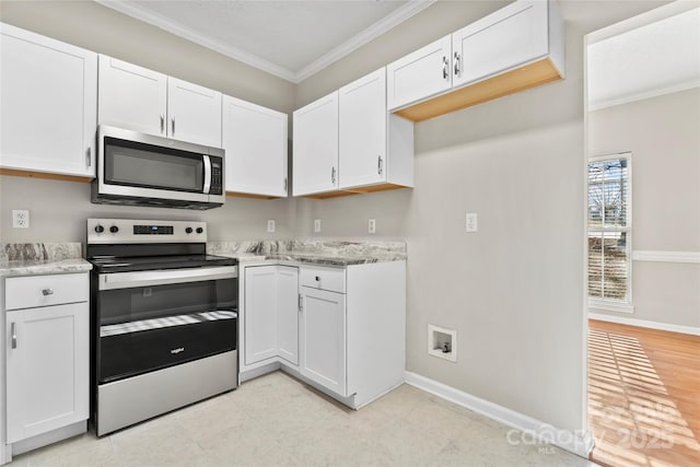 kitchen with white cabinets, appliances with stainless steel finishes, light stone counters, and ornamental molding