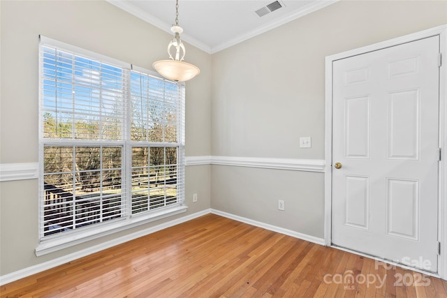 unfurnished dining area featuring hardwood / wood-style floors and crown molding