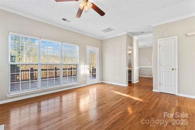 empty room with hardwood / wood-style floors, ceiling fan, crown molding, and a textured ceiling