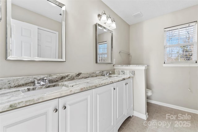 bathroom with tile patterned flooring, vanity, toilet, and a textured ceiling