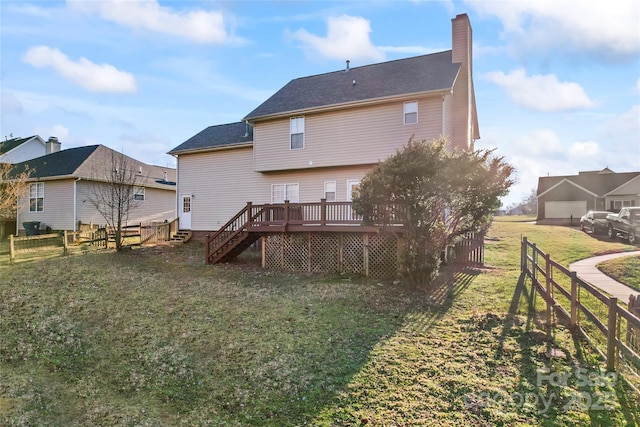 rear view of house with a lawn and a wooden deck