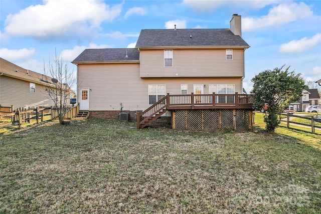 back of property with a deck, central AC unit, and a lawn