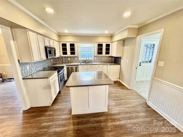 kitchen featuring dark wood-type flooring, sink, a kitchen island, white cabinetry, and stainless steel appliances