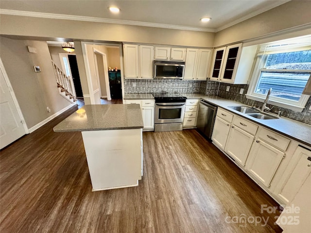 kitchen featuring sink, stainless steel appliances, dark hardwood / wood-style flooring, decorative backsplash, and white cabinets