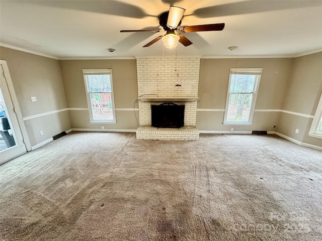 unfurnished living room featuring ceiling fan, plenty of natural light, carpet floors, and ornamental molding