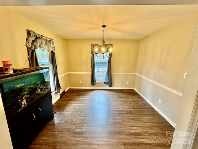 dining room with plenty of natural light, dark wood-type flooring, and a notable chandelier