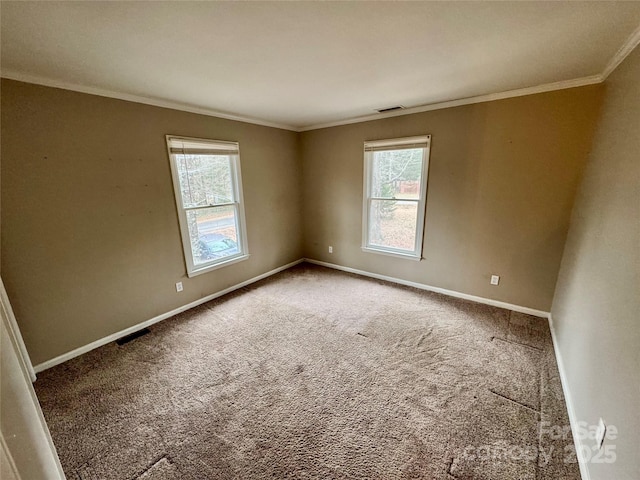 carpeted empty room featuring a wealth of natural light and ornamental molding