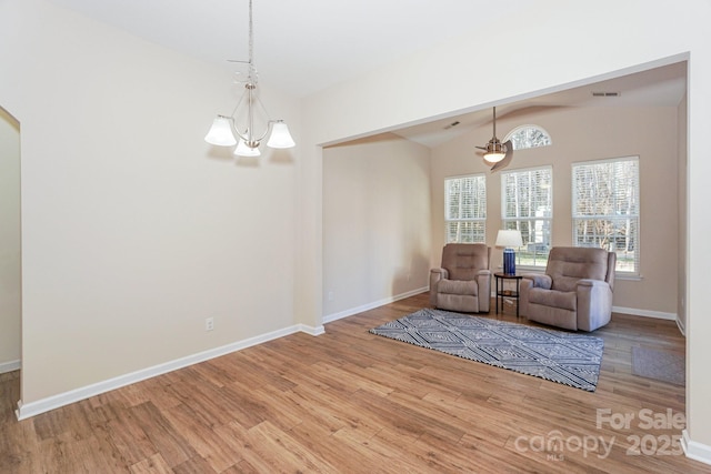 unfurnished room with light hardwood / wood-style floors, vaulted ceiling, and a notable chandelier