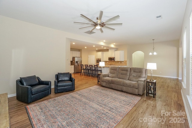 living room featuring ceiling fan and light hardwood / wood-style floors