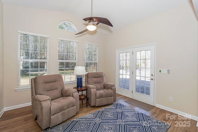 living area with vaulted ceiling, a wealth of natural light, and wood-type flooring