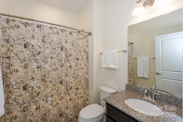 bathroom with curtained shower, toilet, and vanity