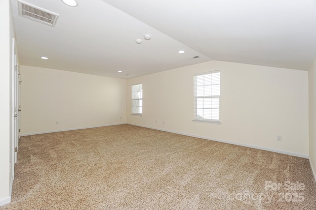 carpeted empty room with lofted ceiling