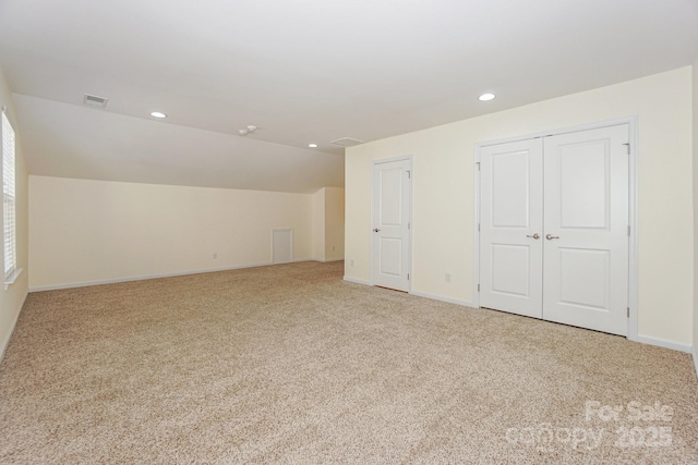 bonus room with light colored carpet and lofted ceiling