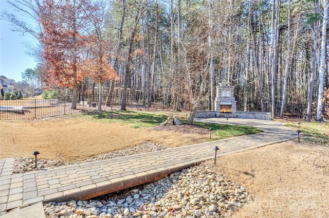 view of yard featuring an outdoor stone fireplace