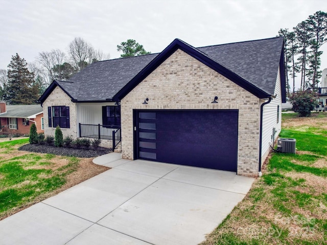 view of front facade featuring cooling unit, a garage, brick siding, a shingled roof, and driveway