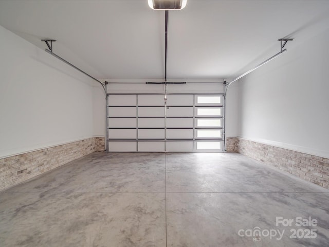 garage with wainscoting and a garage door opener