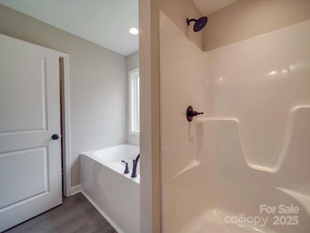 bathroom featuring a shower, wood finished floors, and a bath