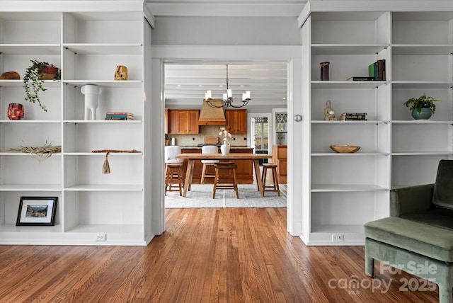 interior space with wood-type flooring and an inviting chandelier