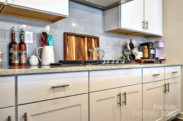 kitchen featuring white cabinetry, stainless steel gas cooktop, and tasteful backsplash