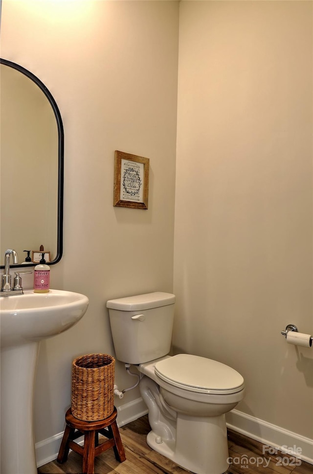 bathroom featuring toilet, sink, and hardwood / wood-style floors