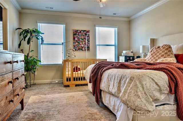 carpeted bedroom featuring ceiling fan and crown molding