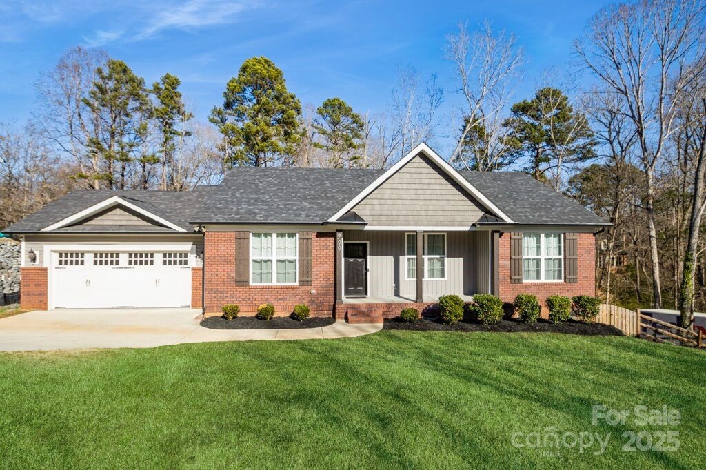 ranch-style house with a garage and a front lawn