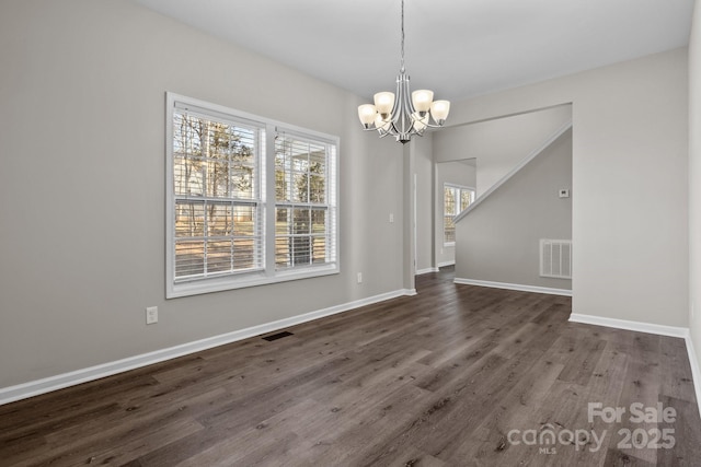 unfurnished dining area with dark hardwood / wood-style flooring and a notable chandelier