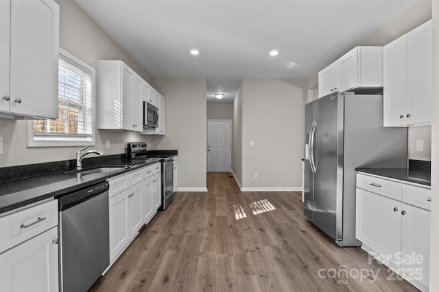 kitchen featuring stainless steel appliances, white cabinets, and sink