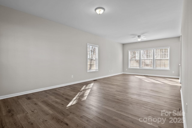 empty room with dark wood-type flooring and ceiling fan