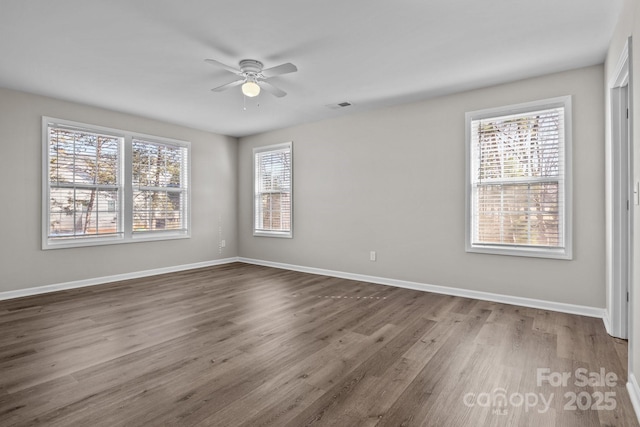 empty room with ceiling fan and dark hardwood / wood-style flooring