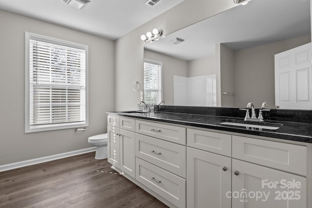 bathroom featuring toilet, hardwood / wood-style flooring, and vanity