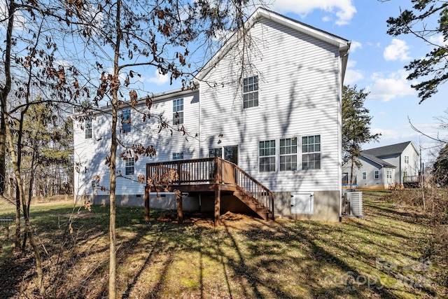 back of house with central AC, a deck, and a yard