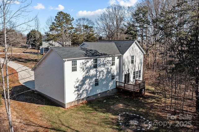 view of property exterior featuring a wooden deck and a lawn