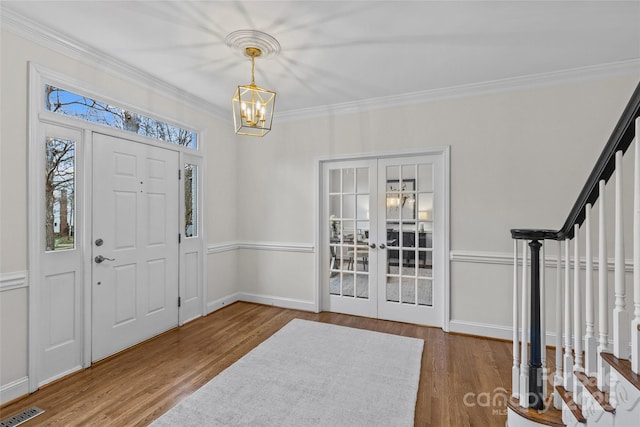 entryway featuring french doors, ornamental molding, an inviting chandelier, and wood-type flooring