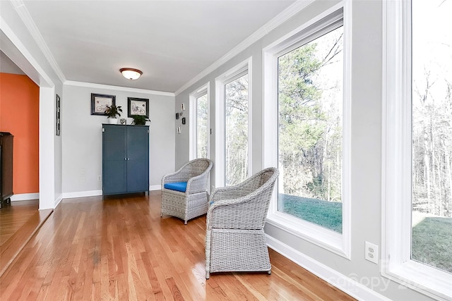 sitting room featuring hardwood / wood-style flooring, crown molding, and a wealth of natural light