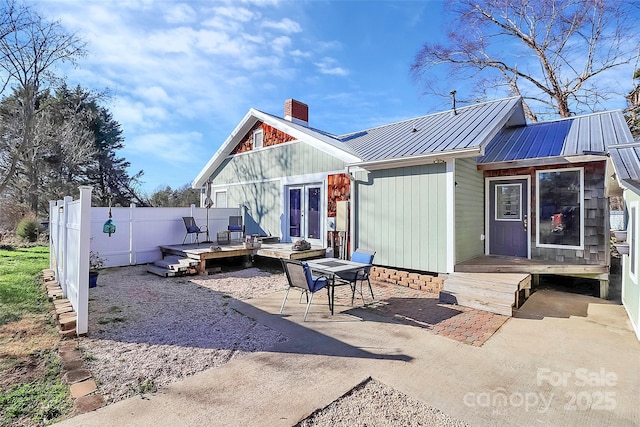 rear view of property with a deck and a patio