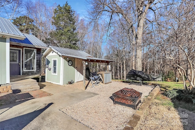 view of patio with an outbuilding and a fire pit