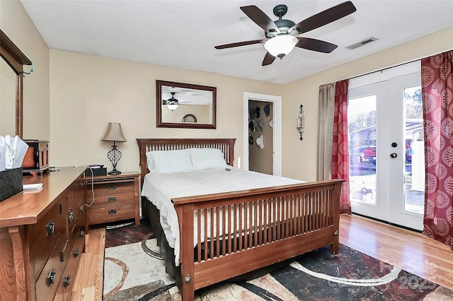 bedroom with french doors, a textured ceiling, light hardwood / wood-style flooring, access to outside, and ceiling fan