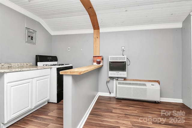 kitchen featuring lofted ceiling, white gas stove, heating unit, dark hardwood / wood-style floors, and white cabinets