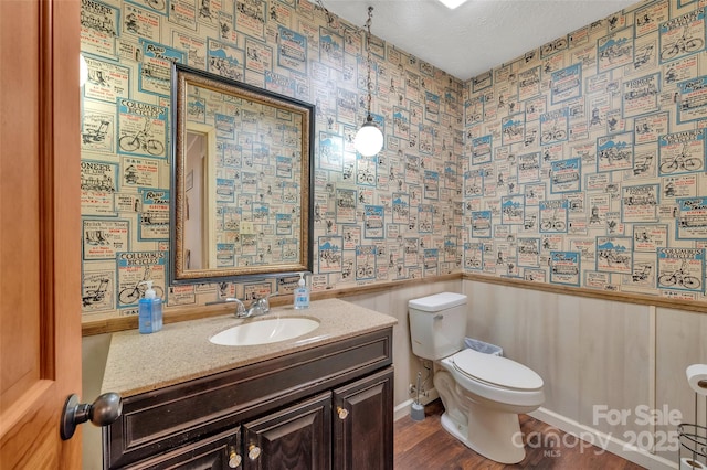 bathroom featuring hardwood / wood-style flooring, vanity, toilet, and a textured ceiling