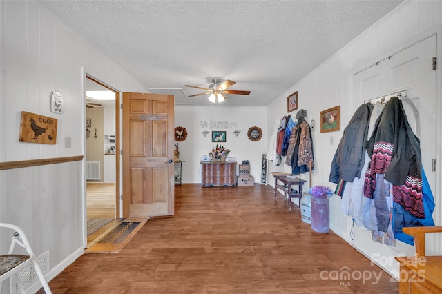 corridor with hardwood / wood-style floors and a textured ceiling