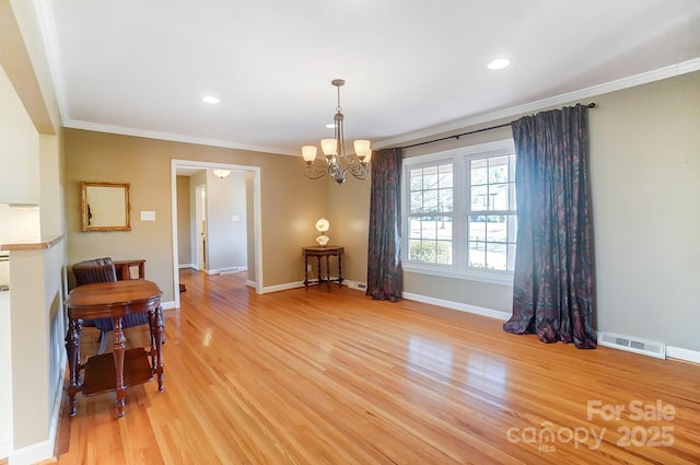 dining space with an inviting chandelier, ornamental molding, and light hardwood / wood-style flooring