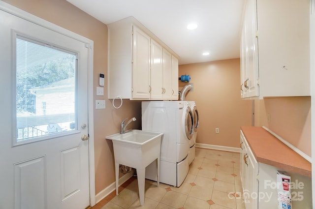 laundry room featuring washing machine and dryer, cabinets, and light tile patterned flooring