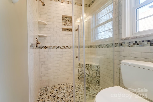 bathroom featuring a shower with shower door, tile walls, and toilet