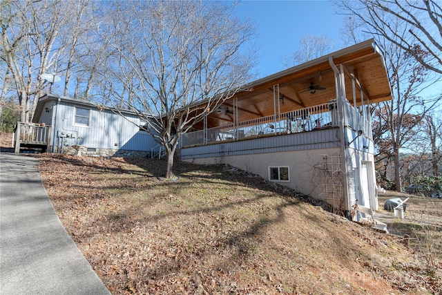 view of side of home featuring ceiling fan and a garage