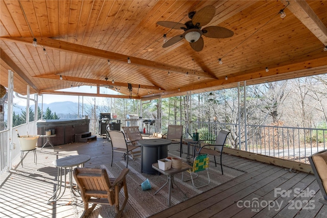 wooden terrace with a mountain view, a hot tub, and ceiling fan